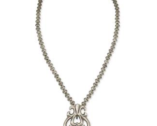 312
A Southwest Navajo sandcast silver pendant necklace
Mid-20th century
Unmarked
Featuring a sandcast sterling silver naja-style pendant suspended from a single strand of silver beads
25 3/4" L x 2 3/4" H
73.0 grams
Estimate: $200 - $400