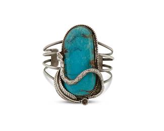278
A Southwest silver and turquoise cuff bracelet
Mid/late 20th century
Unmarked
A delicate four-wire cuff featuring a large set slab turquoise with a snake and feather overlay motifs
6 3/4" inner C x 2 7/8" H, with a 1 3/8" gap
56.5 grams gross
Estimate: $300 - $500