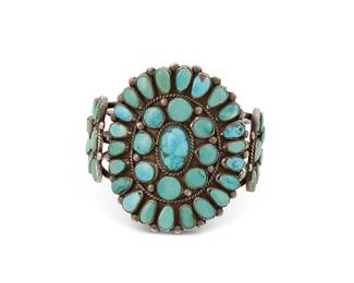 274
A Southwest silver and turquoise cuff bracelet
Mid-20th century
Unmarked
A three-wire cuff with large cluster-set turquoise oval plaque and two flanking plaques to shoulders
6 1/2" inner C x 2 5/8" H, with a 1 3/8" gap
68.3 grams gross
Estimate: $500 - $700
