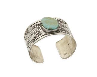 279
A Southwest silver and turquoise cuff bracelet
Late 20th century
Stamped with unknown cipher
A chunky sterling silver cuff with elaborate stampwork surrounding a central set turquoise stone
6 3/4" inner C x 1 7/16" H, with a 7/8" gap
90.2 grams gross
Estimate: $200 - $400