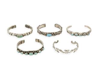 295
A group of Southwest silver and turquoise bracelets
Mid/late 20th century
Three marked: Sterling; one further marked: HB
Comprising four silver and set turquoise narrow cuffs in various designs, as well as a narrow silver cuff with a scrollwork motif, 5 pieces
Largest: 6.5" inner C x 3/8" H; smallest: 6 1/8" inner C x 1/2" H
150.9 grams gross
Estimate: $300 - $500