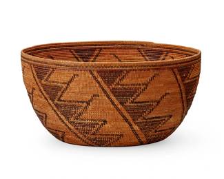 130
A Yokuts polychrome basket
Early 20th century; Southern California
A large coiled oval bowl with brown and red spiraled sawtooth motifs
6.875" H x 14" W x 13.25" D
Estimate: $800 - $1,200
