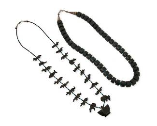 347
Two Southwest stone necklaces
Late 20th century
Comprising a carved jet and turquoise heishi fetish necklace with a central stylized bird, flanked by carved jet bears, bison, fish, birds, and frogs, together with a chunky black stone disc bead necklace with turquoise spacers and silver cone clasp, 2 pieces
28" L and 26" L
230.3 grams gross
Estimate: $200 - $400