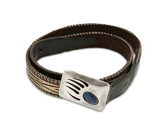 269
A Southwest sterling silver belt buckle and horsehair belt
Late 20th century
Stamped: J. Wright [possibly Jerome Wright, Navajo/Diné] / Sterling; belt marked: 40
A Hopi-style silver shadowbox bear claw buckle with set blue hardstone, mounted to a woven horsehair belt with tooled black leather accents
Buckle: 2 1/4" H x 3" W; belt: 45 3/4" L x 1 1/2" H
Buckle: 75.8 grams gross
Estimate: $400 - $600