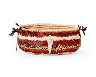 105
An Enrique Arroyo Pomo feathered gift basket
Mid-20th century; Central California
The Enrique Arroyo (b. 20th century) coiled basket adorned with feathers, featuring five strands of clam shell disc beads terminating in abalone pendants
Body: 3.125" H x 7.75" Dia.; With quail feathers: 9.5" Dia.
Estimate: $700 - $900