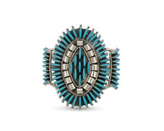 271
A Southwest Zuni-style sterling silver needlepoint cuff bracelet
Late 20th century
Stamped: LH / Sterling
A three wire cuff featuring a large oval plaque with set needlepoint block turquoise
6 1/2" inner C x 2 7/8" H
48.9 grams gross
Estimate: $400 - $600