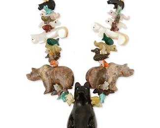 333
A Zuni Pueblo-style carved multistone and jet stacked fetish necklace
Late 20th century
Featuring an elaborate single strand necklace of graduated stacked carved animal fetish figures, including a large central carved jet standing bear, flanked by smaller bears and carved shell mountain lions, with various animals such as birds, foxes, turtles, and wolves, in stones including malachite, sugilite, pipestone, shell, and turquoise, and with heishi beads and a traditional wrapped neck cord
32" L x 2.5" H
192.0 grams gross
Estimate: $200 - $400
