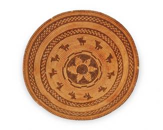 159
An Apache pictorial basket
Early 20th century; Southwest United States
The coiled wide tray with rim ticking above brown checkered and figural animal motifs centering a star motif
4.5" H x 15.75" Dia.
Estimate: $800 - $1,200