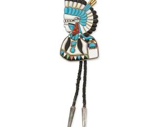 311
A Juan Martinez Zuni sterling silver and inlaid stone bolo tie
Juan Martinez (b. 20th century; Zuni Pueblo)
Marked : JM / Sterling
A katsina portrait bolo with multicolored shell, onyx, turquoise, and coral cobblestone inlay, on a braided leather cord with silver cone tips
Bolo: 4" H x 2 1/8" W; cord: 38" L
65.1 grams gross
Estimate: $300 - $500