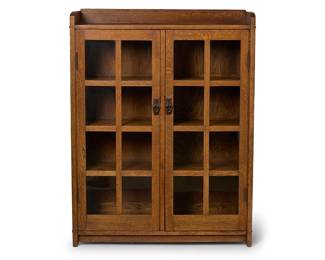 44
A Gustav Stickley bookcase, no. 716
Circa 1900-1910; Eastwood, NY
With Stickley shop mark to upper right interior: Als ik kan / [joiner's compass] / Gustav Stickley; with illegible period tag verso
The fumed quarter-sawn oak bookcase of mortise and tenon construction, with upper gallery above two hinged doors, each with locking mechanism revealing three shelves
56" H x 43.5" W x 13.25" D
Estimate: $2,000 - $3,000