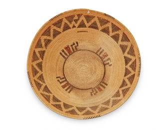 135
A Panamint polychrome basket
Early 20th century; Central California
The coiled basket with rim ticking above a stylized snakeskin pattern centering red and brown linear expressions radiating from a circle
3.5" H x 12.25" Dia.
Estimate: $1,000 - $1,500
