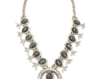 304
A Southwest silver and turquoise squash blossom necklace
Mid/late 20th century
Unmarked
A heavy necklace with a central cast sterling silver naja with shadowbox set turquoise, with twelve matching blossoms suspended from a double strand of silver beads
25" L x 2 3/8 "H
208.1 grams gross
Estimate: $600 - $800