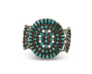 273
A Southwest silver and cluster set turquoise cuff bracelet
Mid-20th century
Etched: HIC [likely; conjoined]
A three-wire cuff with a large circular cluster-set petit point turquoise plaque and flanking cluster-set shoulders
6 1/2" inner C x 2 1/2" H, with a 1 1/8" gap
63.5 grams gross
Estimate: $400 - $600