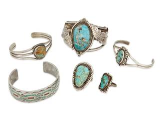 368
A group of Navajo jewelry
Late 20th century
Six works:

Charlie Singer (1931-2018, Diné)
A Navajo sterling silver and stone inlay cuff
Stamped with arrowhead cipher for Charlie Singer
With chipped turquoise and coral inlay and stamped edges
7" total inner C x 7/8" H

A group of stone-set Navajo jewelry
Two marked for maker; one marked: 925
Comprising three silver bracelets including a B. Begay two wire cuff with central set turquoise, and a J. Perry three-wire cuff with large central turquoise and stamped applied leaves , as well as two turquoise and silver rings, 5 pieces
Largest cuff: 6 1/2" inner C x 2 1/4" H; smallest: 7" inner C x 1" H; Ring sizes: 7.5 and 4.5

6 pieces total
183.4 grams gross
Estimate: $400 - $600