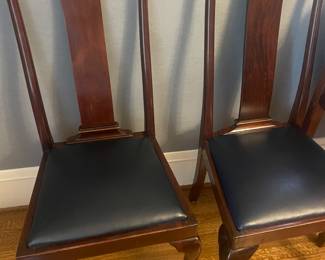 Two of the 10 chairs sold with this set. Seats are dark blue leather