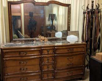 Vintage wood dresser w/ mirror top and decor. Has wheels for easier moving around