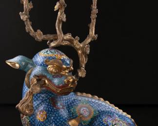 Qing Dynasty - Qianlong Period - Large cloisonne candle holder from cast bronze in the shape of a scaled beasts on a turqoise ground, supporting three tree branches with flowers serving as the candle holders, and gilt bronze accents.

This piece was one of the auction staff favorites because of its mystical and charming visage. It's unique design eludes to the reverence given to such  beloved mythical creatures.
H: 68, W:30  , L:49  CM