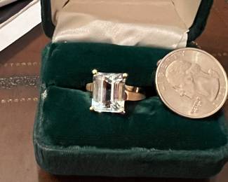 Large solitaire emerald cut stone in gold band