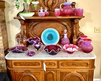 Very rare hand carved pheasant, marble top buffet. This is a gorgeous piece!  Fender Cranberry opalescent and Plum Opalescent Shown.  Blue opalescent large cake plate.  Large Green and white opalescent Epergne.