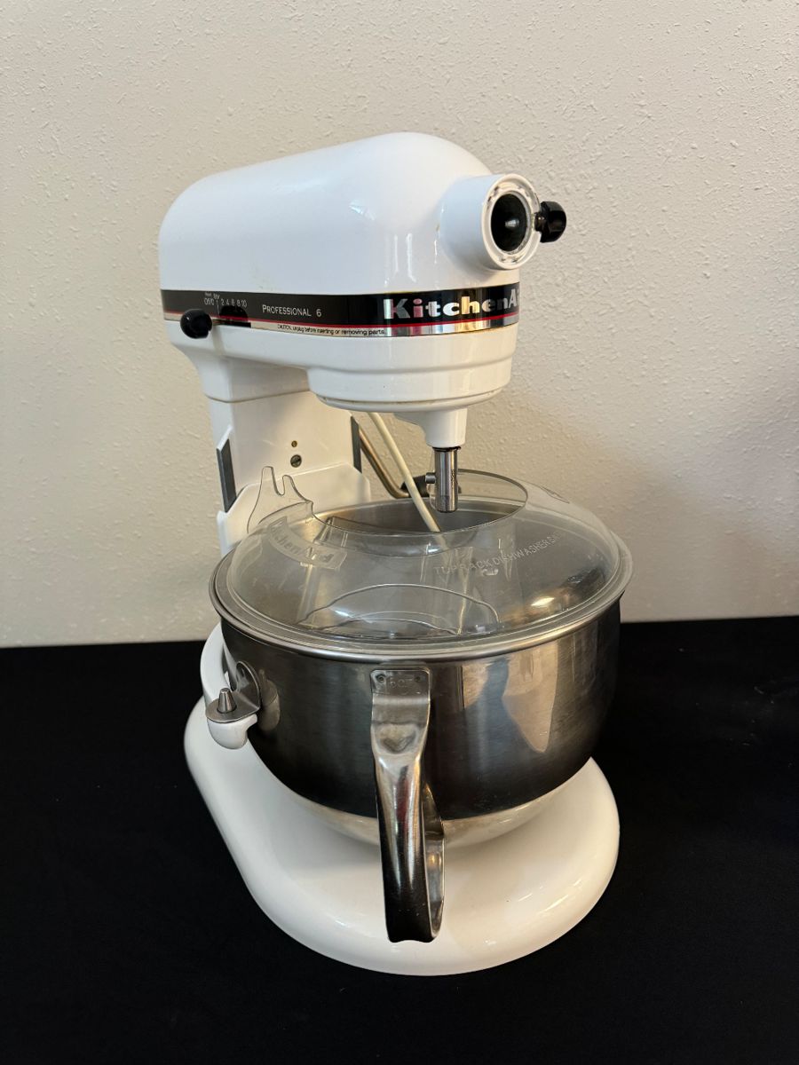 Free standing Kitchen Aide mixer with splatter guard, dough hook, whip and paddle.