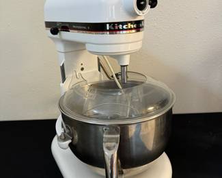 Free standing Kitchen Aide mixer with splatter guard, dough hook, whip and paddle.