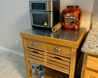 Teak kitchen island with four drawers and underneath storage.