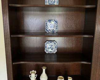 Cherry book/ curio shelf with two shelf covered storage. Belleek shamrock vase and cream/ sugar.