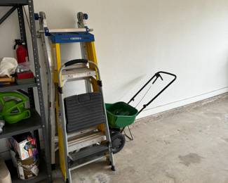 Garage items include hedge trimmers, painting supplies, a small dolly, step ladders and other lawn care equipment.