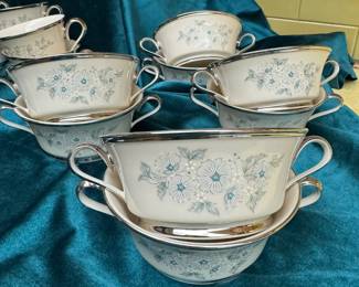 Lenox Windsong china handled soup bowls. RETIRED This Windsong pattern was manufactured for 28 years by the Lenox China Company, based in the USA . The warm, translucent ivory background and the soft, light blue and white floral arrangement are typical Lenox floral genius. Finished with a heavy platinum trim to provide strength on the outside. 