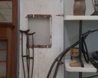 Wood door. Antique crutches.  Antique wheat cutters