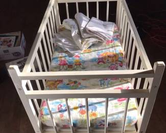 Small baby crib on casters with linens & blanket