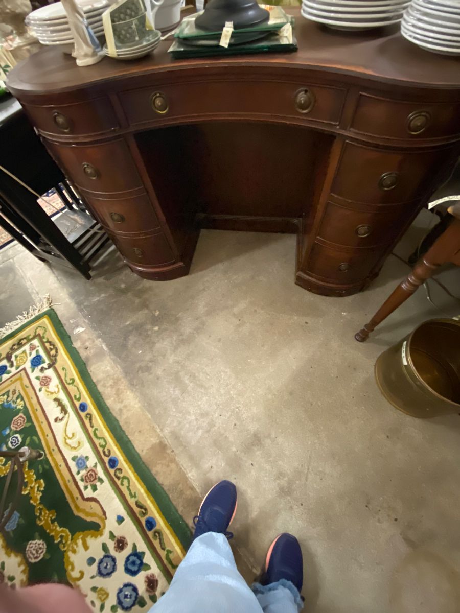 Kidney shaped leather desk; shelves on the other side 