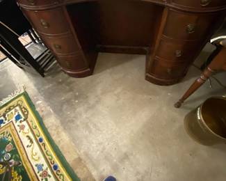 Kidney shaped leather desk; shelves on the other side