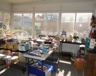 The sunroom is a treasure trove of books, wreaths, furniture and electronics and more