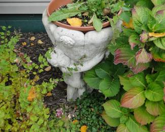 Cherub love planter.  Hint:  It is buried behind a Hydrangea plant.