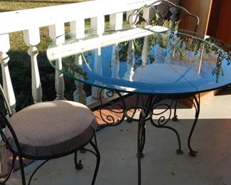 Antique cast iron table and two cast iron chairs very ornate