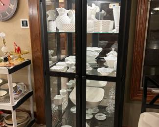 Black lighted curio cabinet filled with milk glass and white hobnail treasures
