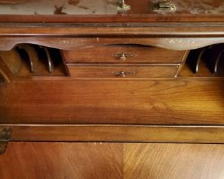 The flat surface below the drawers slides back to find a compartment.