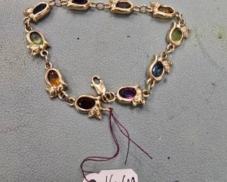 10 karat gold cat bracelet with gemstones.