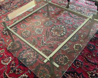 Glass & brass coffee table over large room size oriental carpet