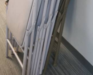 over a dozen metal folding chairs