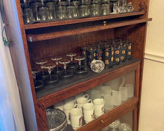 Lawyers bookcase filled with Libby MCM Gold Coin glasses, dark green Libbey glassware set and more