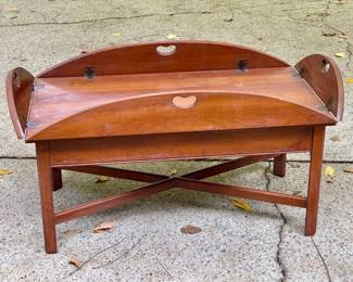 Lot 029-GAR: Vintage Side/Coffee Table

Features: 
•	This vintage table is made in the style of a butler’s tray table, but the top is not removable. It features four foldable sides and the handles on each side resemble hearts, a nod to a more rustic, “country” design motif. The rich, warm wood finish highlights its classic charm, while the sturdy base with crossed supports adds a touch of sophistication. 
•	Hand-made by the Cassady Furniture Company, Bowling Green, KY


Dimensions: 39.5”W x 21.5”D x 17.5”H

Condition: Good pre-owned condition. The piece is structurally solid. Some wear on the finish is visible and some mildew spots are present, as well. A water stain ring is visible on top surface. See pictures for detail. 


