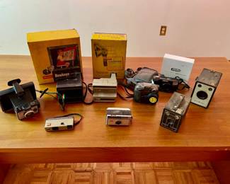 Lot 042-GAR: Cameras & Gear Through the Years

Includes: An assortment of (mostly) vintage mid-20th-century film cameras and accessories
•	Various film cameras by Kodak, Polaroid, Agfa, Olympus
•	One mini-digital camera
•	See pictures for details

Dimensions: For reference: Smallest camera (Hawkeye) 4.5”L


Condition: Poor-to-Good pre-owned condition. We did not examine the cameras’ interiors or test them.
