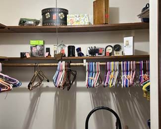 tons of clothes hangers, clocks, decorative boxes, small paper safe with keys, vacuum cleaner, step stool