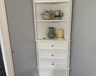 white corner cabinet, pottery pieces 