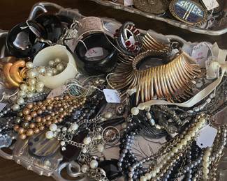 Detail of costume jewelry and a collection of men’s advertising belt buckles
