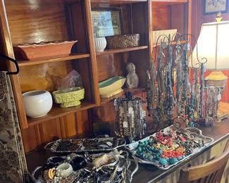 Shelves of McCoy, Hull and miscellaneous pottery. Large selection of costume jewelry on a 1950’s Steelcraft desk