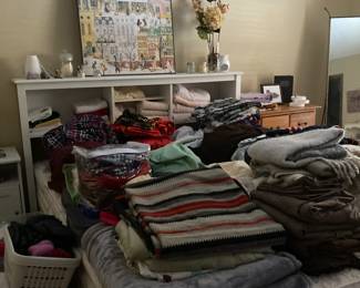 White headboard with niches, blankets, sheets, comforters, towels