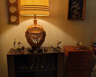 Great brass figurines, large vintage lamp with lighting also in the base.  MCM bookcase, black velvet painting.